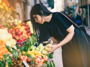 working with dietitian for ulcerative colitis diet, Woman buying fresh fruit from a farmer's market stand