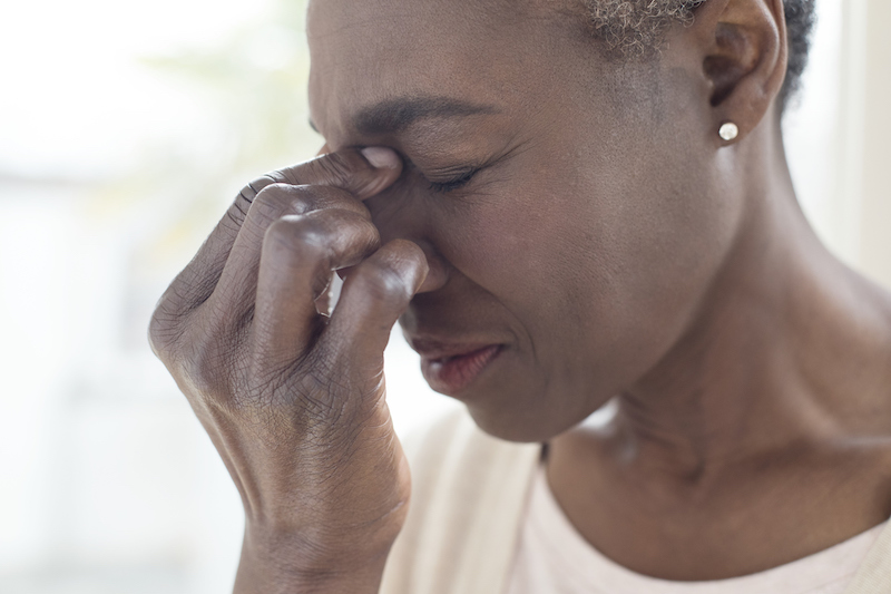 woman experiencing a headache, a common side effect of biologic treatment for IBD