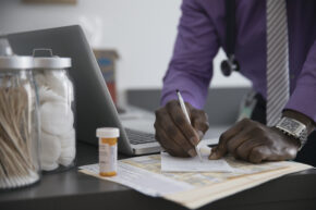doctor writing prescription for anti-inflammatory drugs for IBD