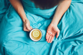 patient in bed with tea taking common antibiotics prescribed for IBD