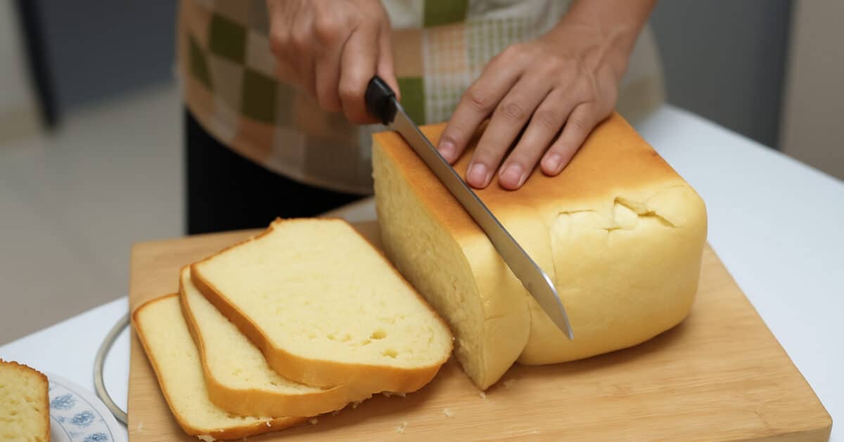 Close up of person slicing bread