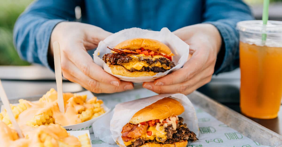 Hands holding a smash burger