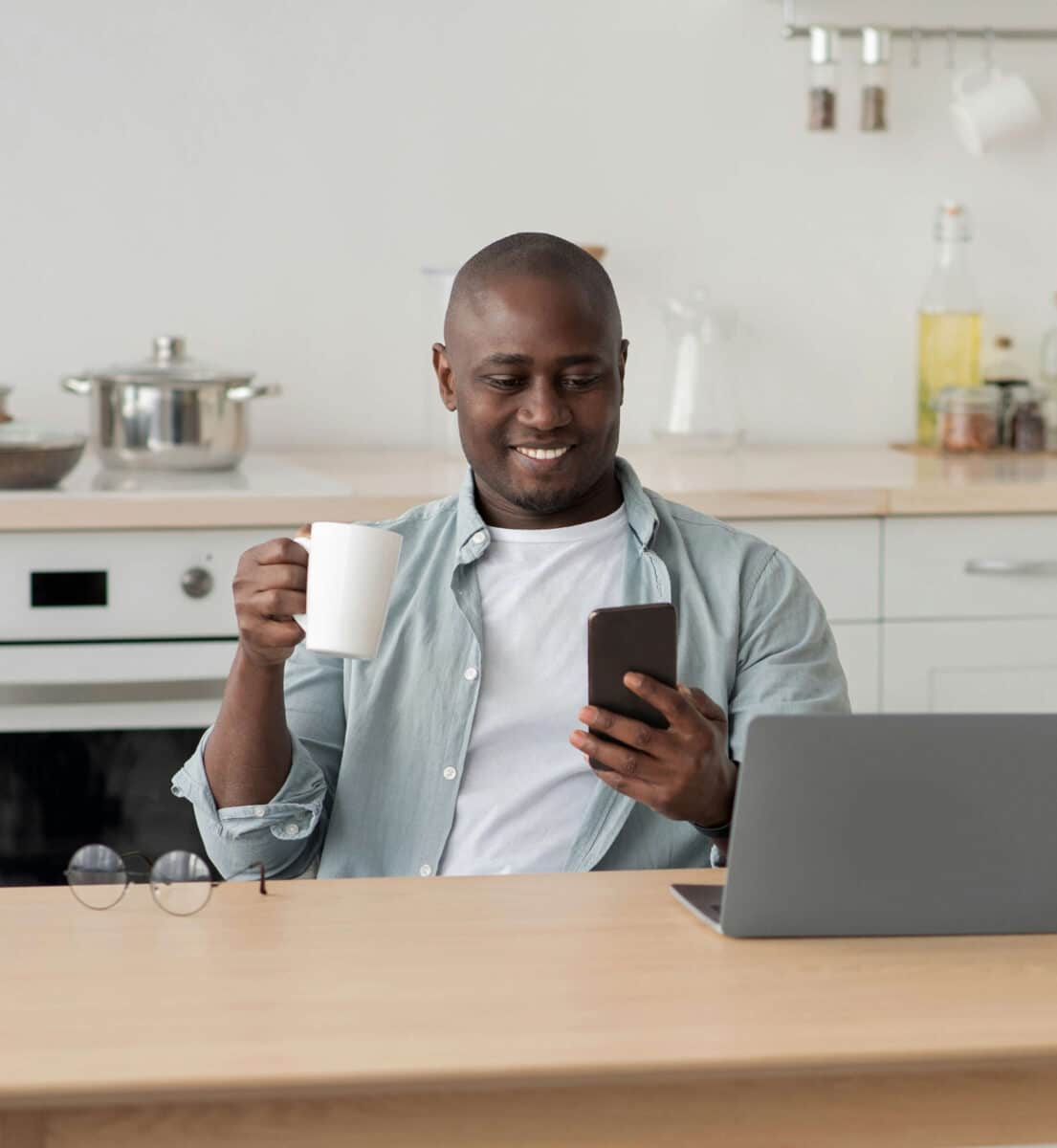 Man holding coffee and looking at phone