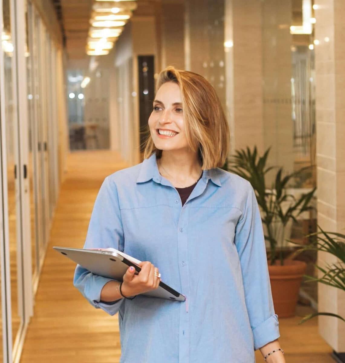 Woman holding laptop in hallway