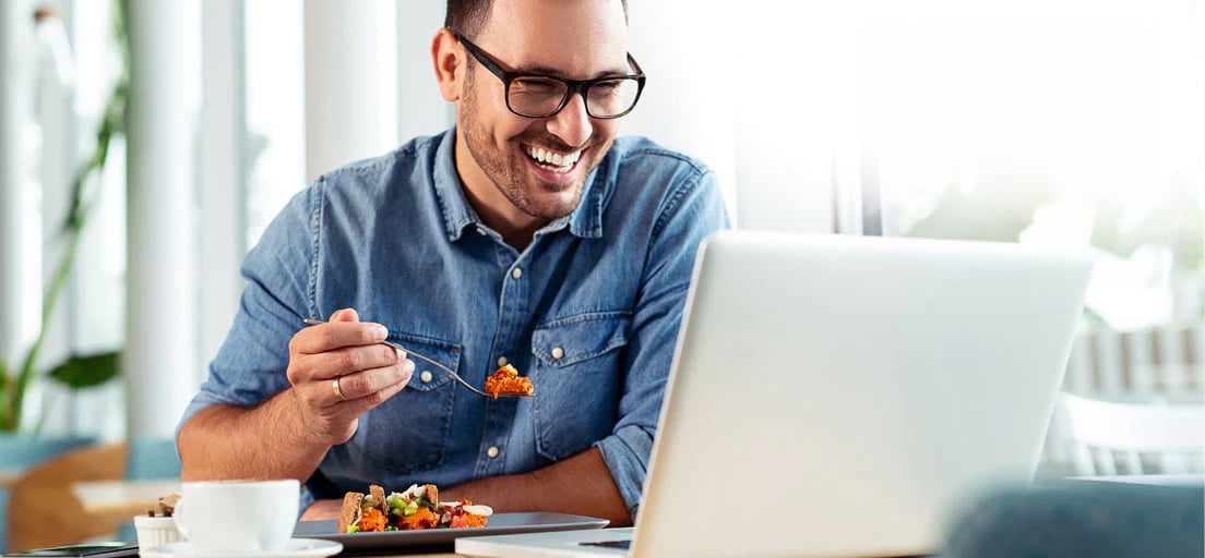 Man eating with laptop