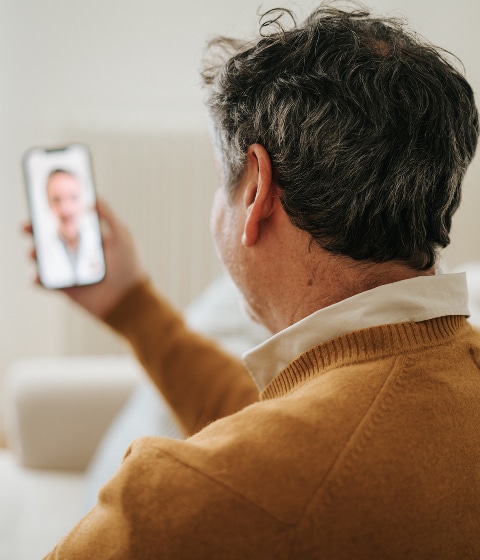 Close-up of person talking to provider via telehealth on their phone