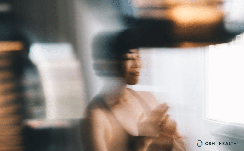 Blurred image of a person with eyes closed and a hand over their chest, conveying the sensation of nausea or dizziness.