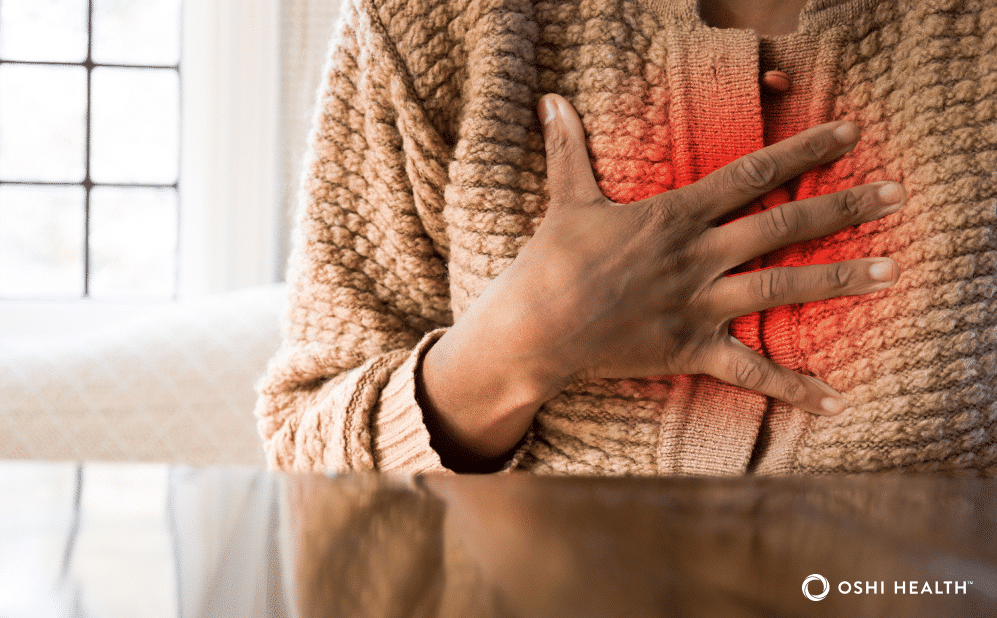 Person experiencing acid reflux while holding their chest.
