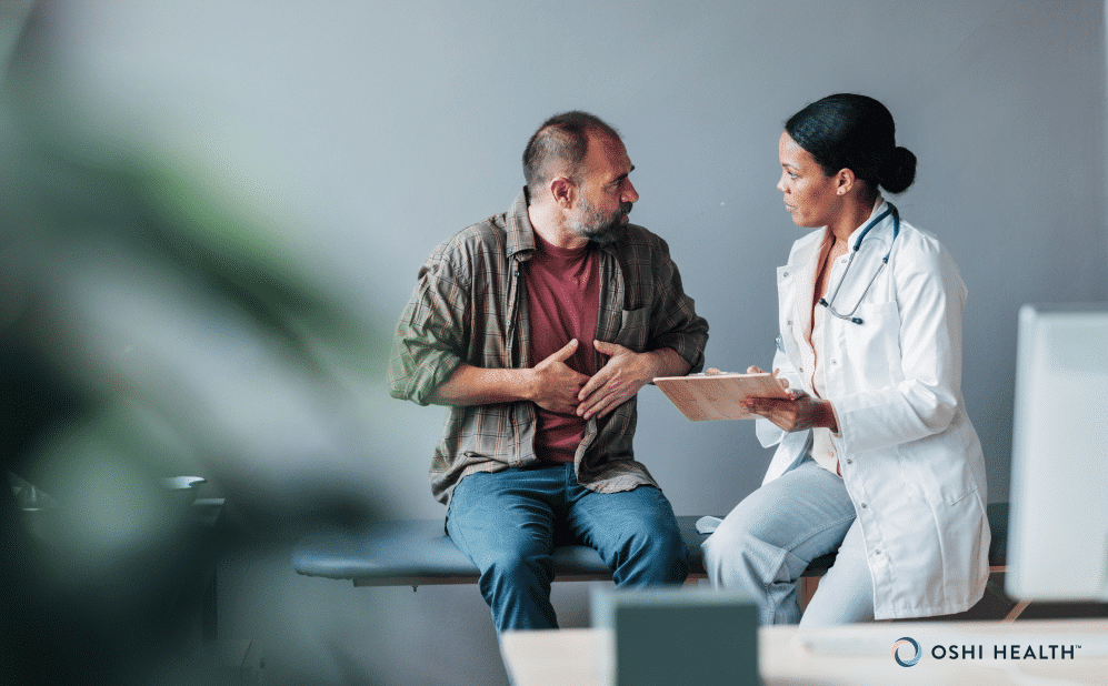 Doctor talking with a patient experiencing abdominal discomfort.